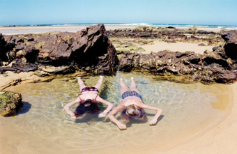 Sandy Edwards, Marina and Laura in Lady Grounds Pool,<BR />Bithry’s Inlet, Tanja, NSW, 1998″></p>
<p class=